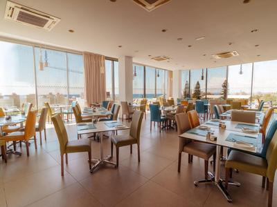 Nowoczesna restauracja z dużymi oknami i widokiem na miasto w hotelu.