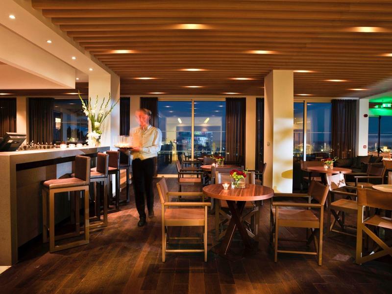 Cozy hotel restaurant with wooden furniture and warm lighting ambiance at night.