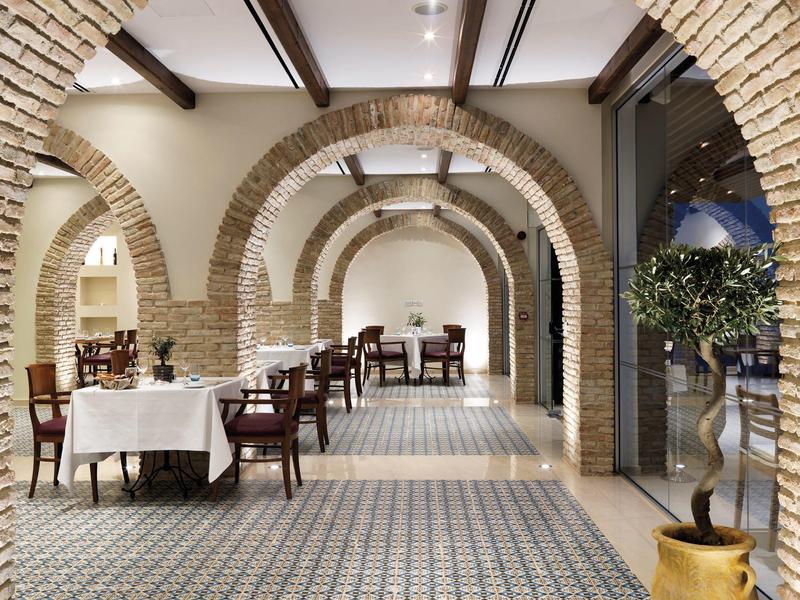 Elegant restaurant with stone arches and stylishly set tables in a hotel.