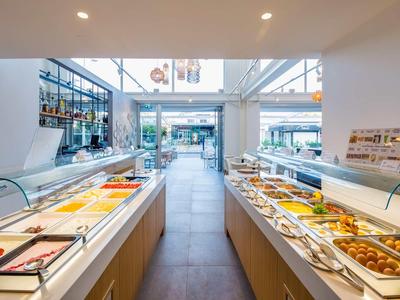 Cucina moderna e luminosa dell'hotel con buffet di insalate e dessert su entrambi i lati