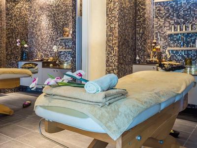 Przytulny pokój do masażu z wygodnymi łóżkami, ciepłymi tonami i relaksującą dekoracją.