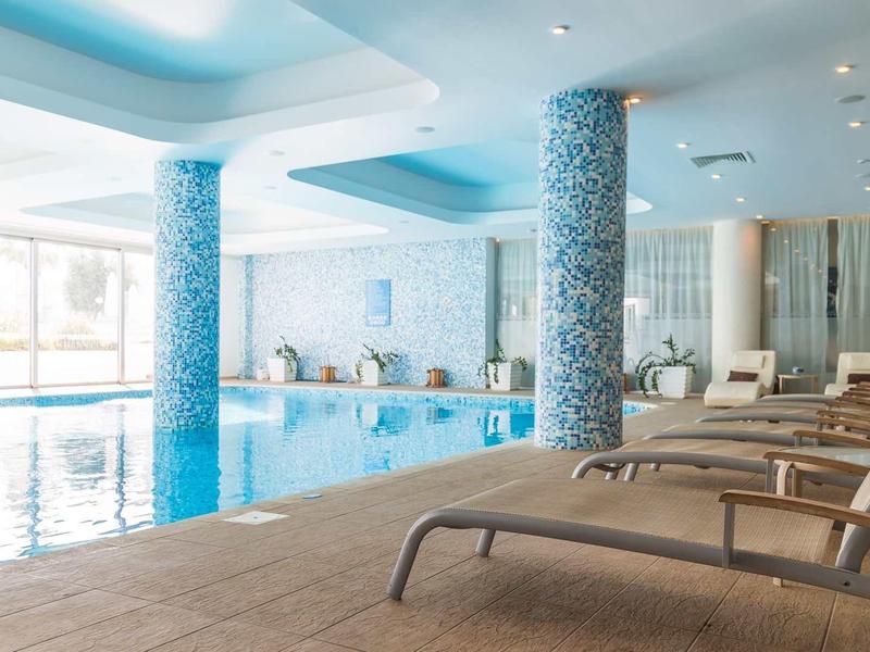 Jasne wnętrze z basenem i leżakami do relaksu w hotelu.
