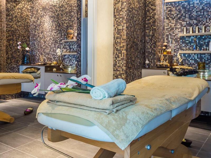 Przytulny pokój do masażu z wygodnymi łóżkami, ciepłymi tonami i relaksującą dekoracją.