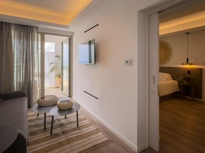 Modernly furnished hotel room with living area and adjoining bedroom.