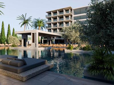 Moderner Hotelkomplex mit Pool, Liegen und Palmen in sonniger Umgebung.