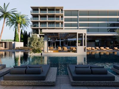 Moderner Hotelpool mit Lounge-Betten und Palmen vor einem Glasgebäude.