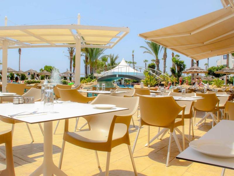 Moderne buitenruimte van een hotel met comfortabele stoelen en zonwering