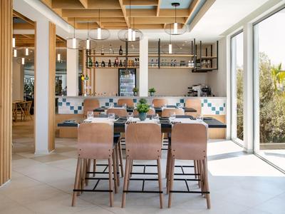 Zona pranzo moderna con mobili in legno e grande finestra con vista esterna.