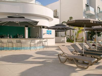 Moderner Außenbereich mit Bar und Liegestühlen in einem Hotel neben dem Pool.