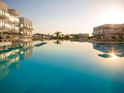 Symmetrischer Blick auf ruhigen Hotelpool bei Sonnenuntergang mit Spiegelungen.