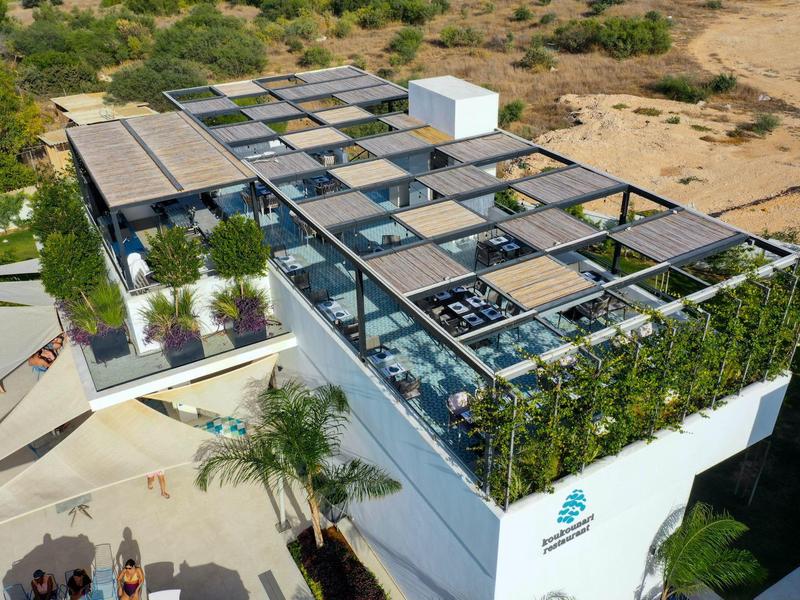 Moderner Gebäudekomplex mit begrüntem Dach und Außenbereichen in sonniger Lage.