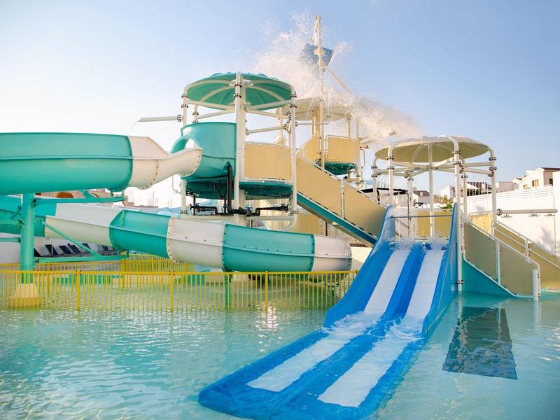 Bunte Wasserrutschen, die in ein Schwimmbecken in einem Wasserpark führen.