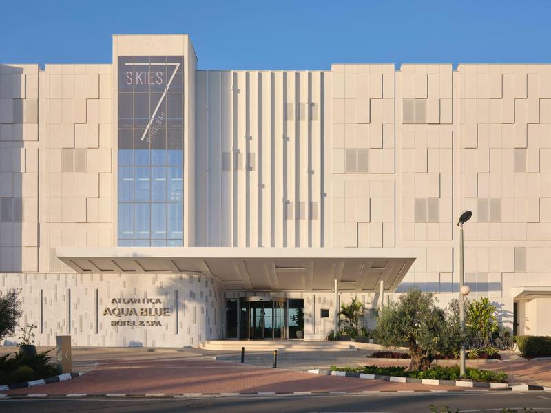 Modernes Hotelgebäude mit geometrischer Fassade und Eingangsbereich mit Überdachung.