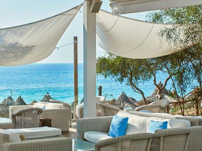 Gemütliche Lounge mit weißen Möbeln und Blick aufs Meer, ideal zum Entspannen im Urlaub.