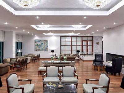Eleganter Hotel-Loungebereich mit bequemen Sesseln, Holzboden und stimmungsvoller Beleuchtung.