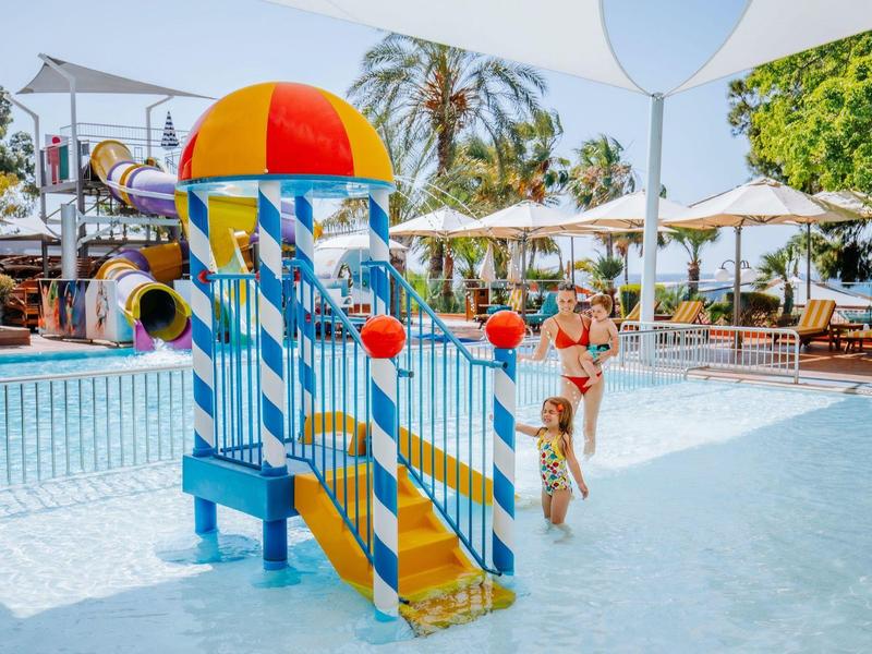 Barevné vodní hřiště se skluzavkami v mělké části hotelového bazénu.