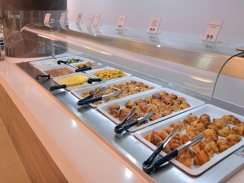 Buffet mit warmen Speisen wie Gemüse, Nudeln, Fleisch und Kartoffeln in Edelstahlbehältern.