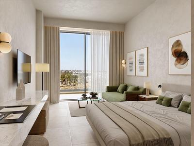 Modern hotelkamer met groot bed, bank en uitzicht op de stad door grote ramen.