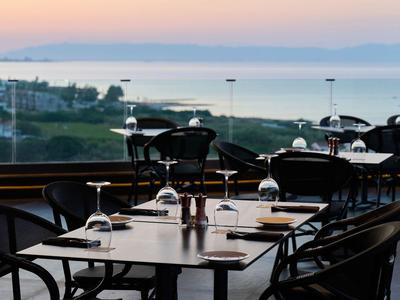 Area esterna moderna di un hotel con vista sul mare al tramonto.