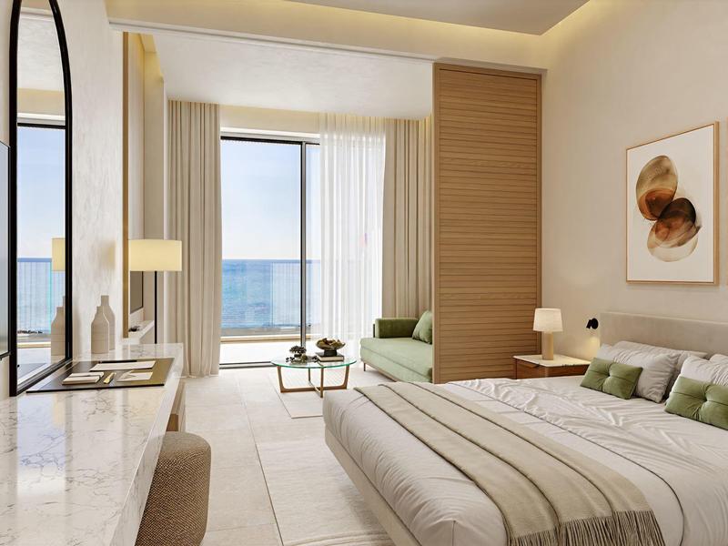 Lichte kamer met tweepersoonsbed, balkon en uitzicht op zee, modern en gezellig ingericht.