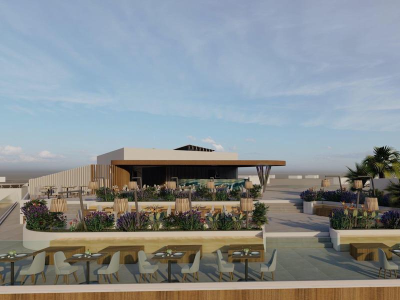 Moderne buitenruimte van een hotel met tafels, stoelen en palmbomen onder een blauwe lucht.