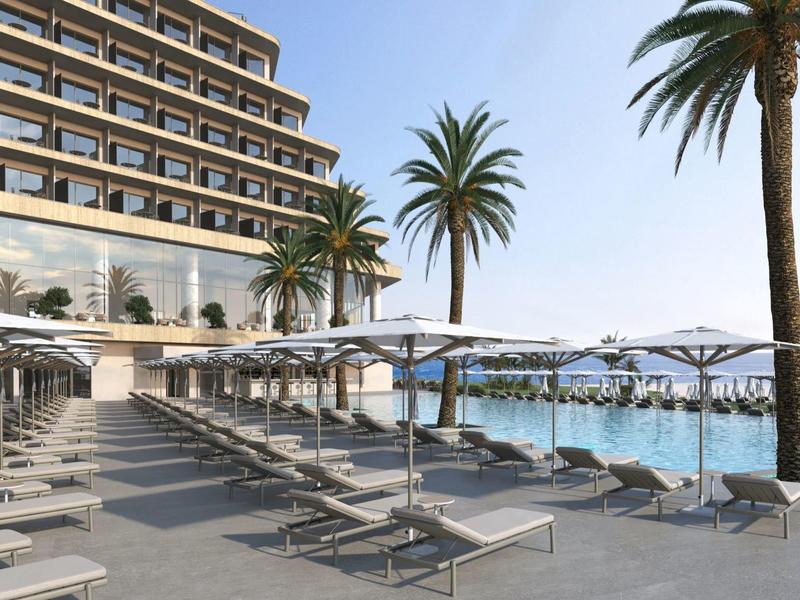 Moderne hotelterras met ligbedden en palmbomen aan zee