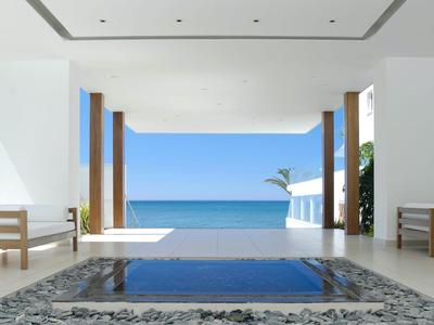 Área moderna y abierta del hotel con vista al mar y una pequeña piscina en primer plano