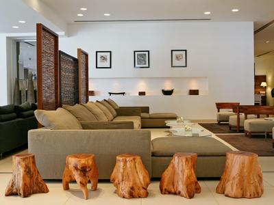 Salón moderno con sofás beige, taburetes de troncos de madera y decoración minimalista.