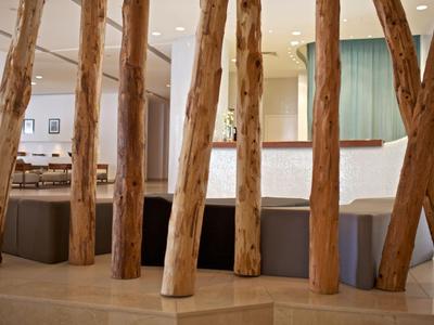 Área moderna del hotel con troncos de madera como divisores y asientos cómodos.