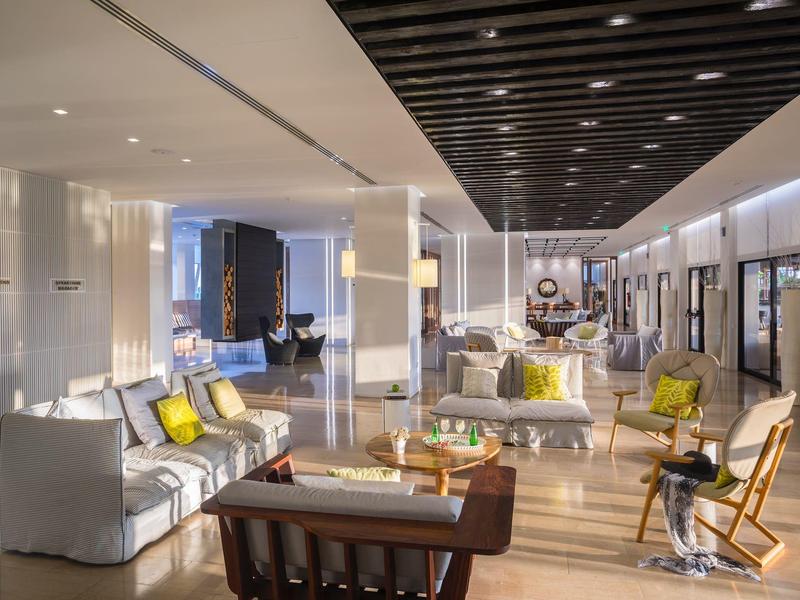 Espace de lobby d'hôtel élégant avec mobilier moderne, lumière chaude et décoration stylée.