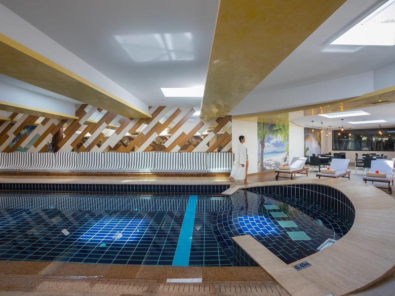 Piscine intérieure au design moderne avec revêtement en bois dans un hôtel