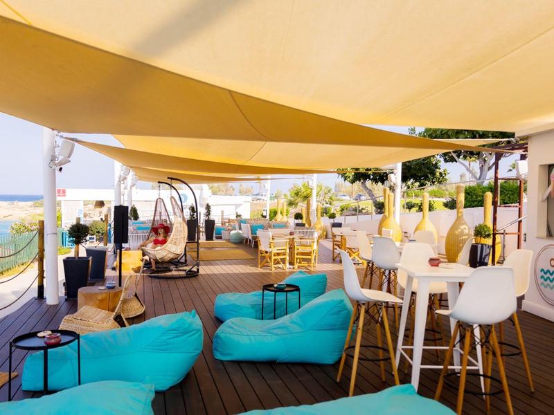 Salon extérieur moderne d'hôtel avec poufs confortables et vue sur mer