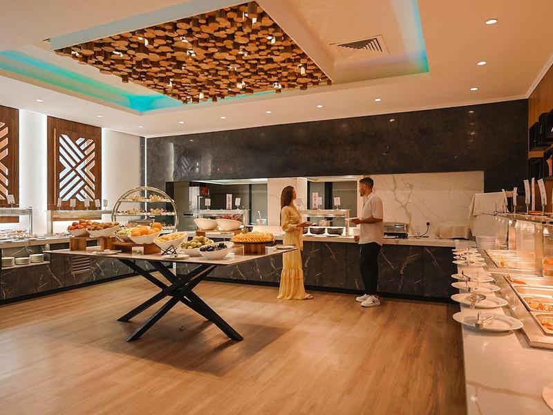 Buffet moderne avec une variété de plats dans une salle à manger élégante et bien éclairée.