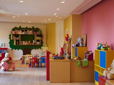 Bunter Kinderspielraum mit Tischen, Stühlen und Spielzeugen in einer gemütlichen Ecke.