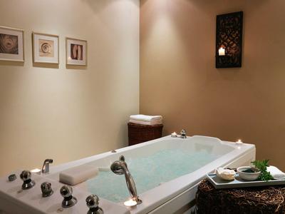 Moderner Whirlpool in einem gemütlichen Raum mit indirekter Beleuchtung und dekorativen Elementen.