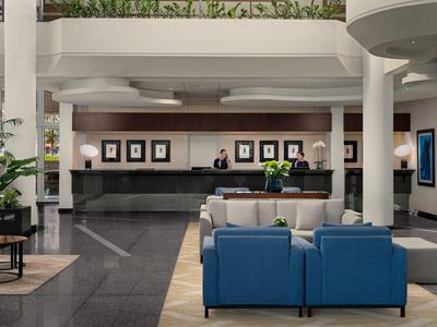Hotel-Lobby mit Empfangstresen, blauem Sofa und moderner Innenarchitektur.