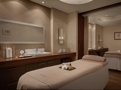 Ein ruhiger Spa-Raum mit zwei Massageliegen, gedämpftem Licht und entspannender Atmosphäre.