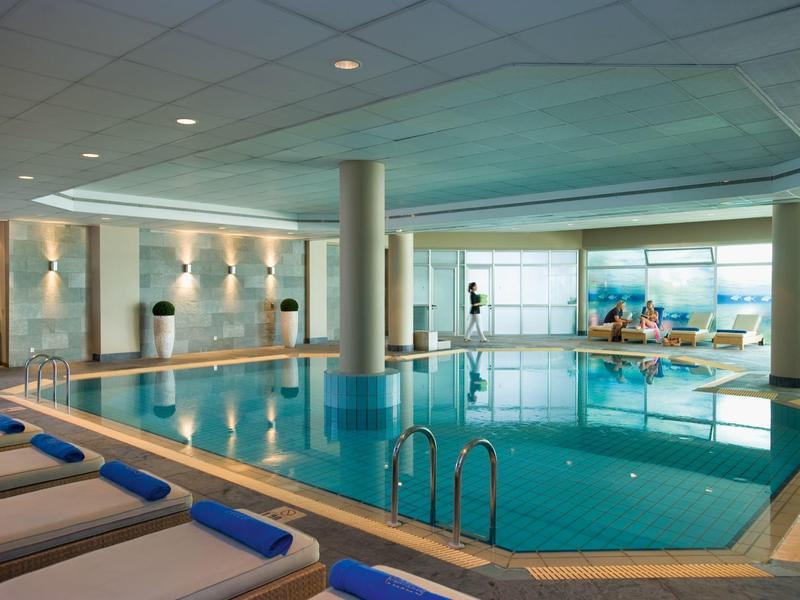 Indoor pool with lounge chairs and panoramic windows in a hotel