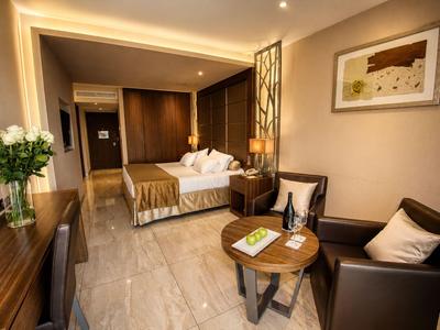 Une chambre d'hôtel moderne avec un lit double, un coin salon et un éclairage élégant.