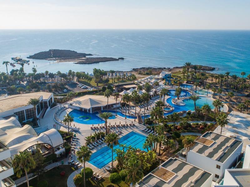 Luxuriöses Resort mit mehreren Pools auf einer Küstenlage mit Blick auf das blaue Meer.