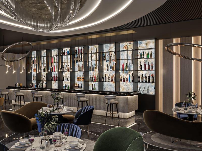 Elegantes Restaurant mit rundem Kronleuchter, Barbereich und stilvollen Sitzgruppen in warmem Licht.