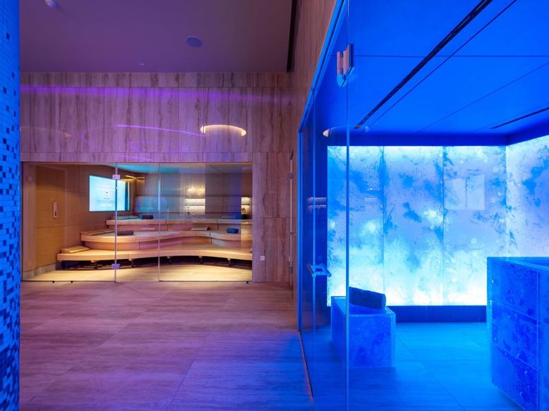 Moderner Spa-Bereich mit Sauna und blau beleuchtetem Ruheraum.