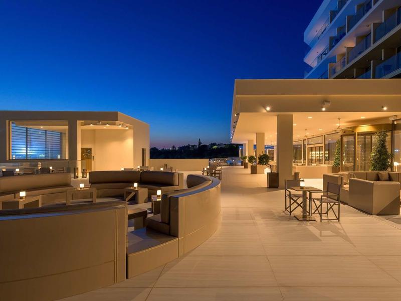 Moderner Außenbereich mit Sitzgelegenheiten, Beleuchtung und klarer Abendhimmel im Hintergrund.