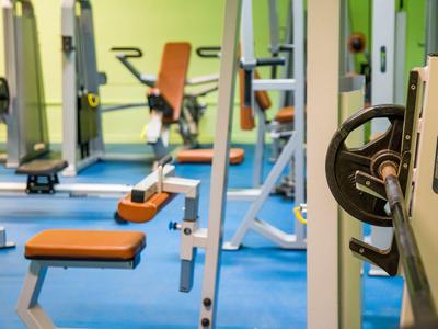 Fitnessraum mit Trainingsgeräten und buntem Boden in einem Hotel