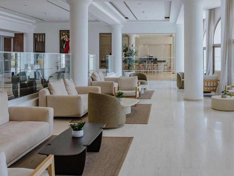 Hall d'hôtel lumineux avec canapés confortables, fauteuils et grandes fenêtres