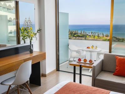 Chambre d'hôtel moderne avec balcon et vue sur la mer et la promenade.