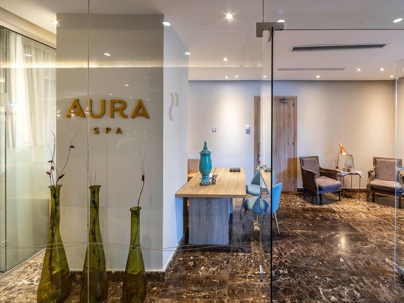 Entrée moderne du spa avec parois en verre et sièges élégants.