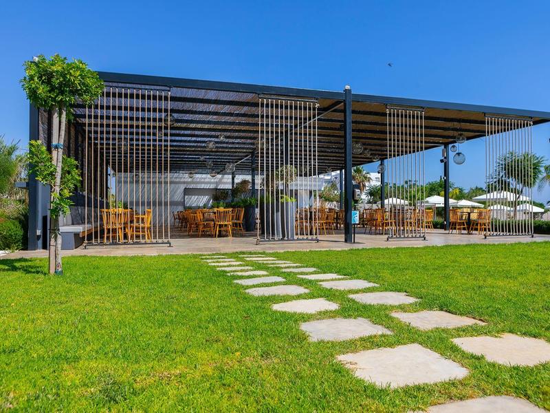 Restaurant de jardin moderne avec pelouse verte et escalier en pierre extérieur