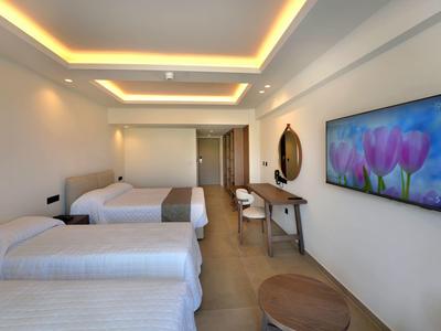 Modernes Hotelzimmer mit zwei Einzelbetten, elegantem Schreibtisch und großem TV an der Wand.