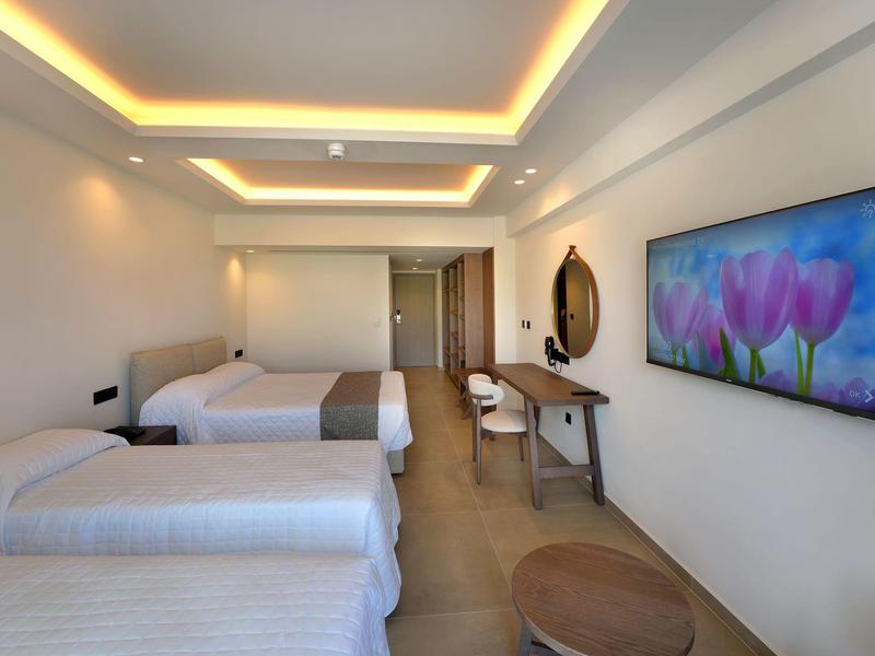 Modernes Hotelzimmer mit zwei Einzelbetten, elegantem Schreibtisch und großem TV an der Wand.